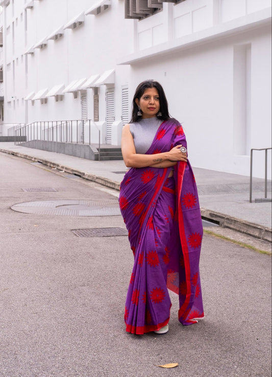 A woman in purple cotton saree with red floral print