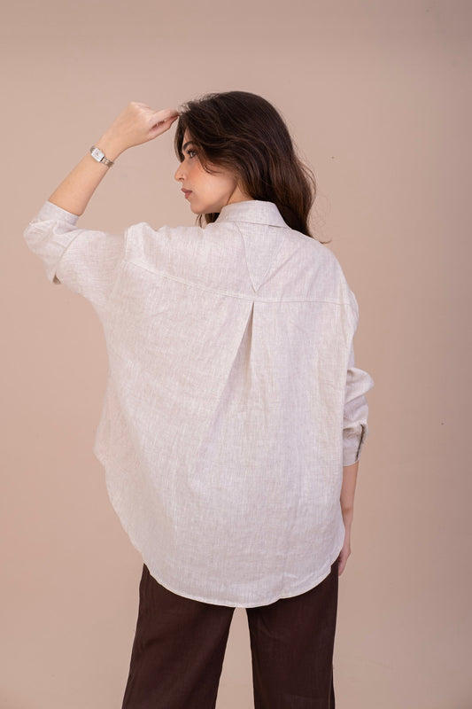 Back view of a woman in oversized pure linen shirt in a beige natural linen colour.