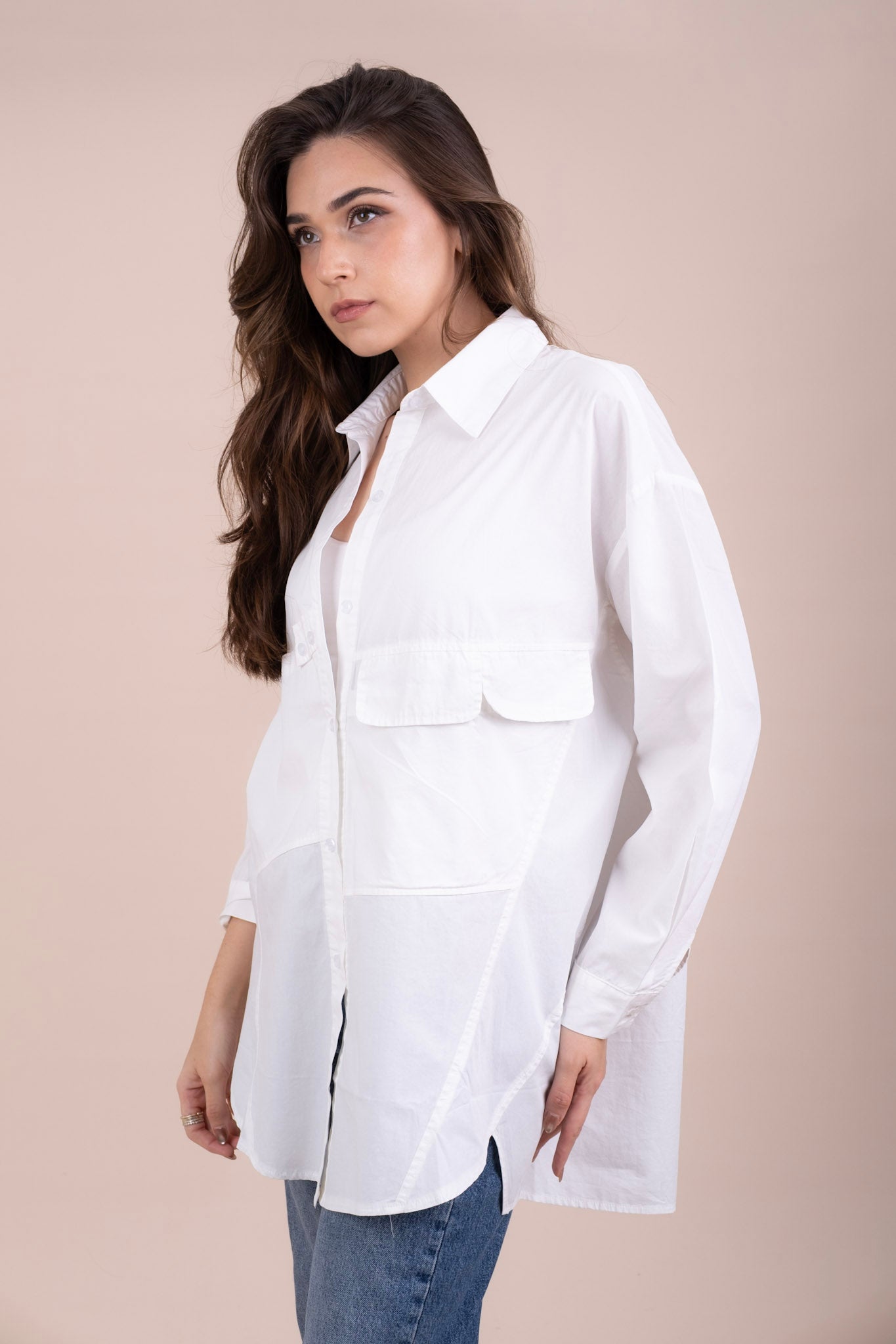 Women's white long-sleeve button-up oversized shirt with chest flap pockets.