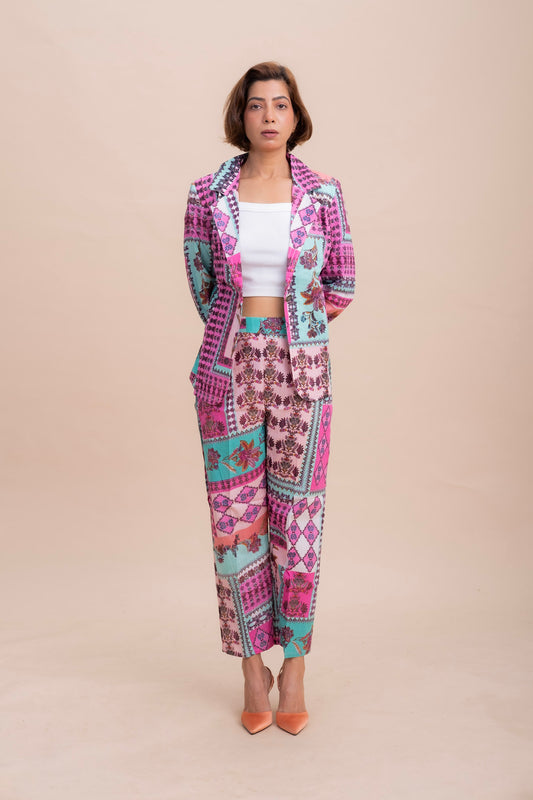 A woman coord set in pink and purple geometric patterned blazer and matching trousers